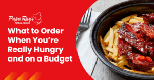 A bowl of saucy ribs and crispy fries sits on a table next to a fork, featured in a Papa Ray’s Pizza & Wings graphic titled “What to Order When You’re Really Hungry and on a Budget