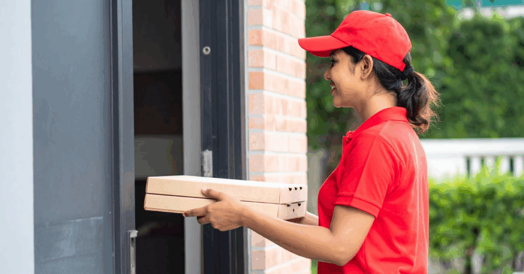 ALT: “Pizza delivery person handing hot pizza box to customer”