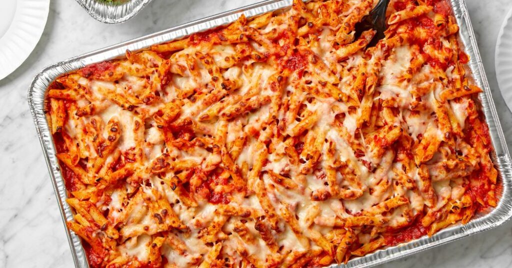 Papa Ray’s catering trays with pizza, wings, and pasta for parties”)