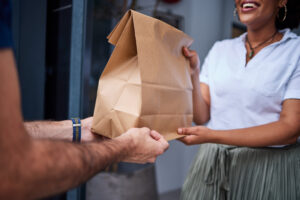 delivery customer hands with paper bag door from courier man home giving woman client package parcel fast food from online shopping ecommerce distribution service