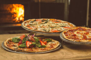 Pizza Restaurants in Carol Stream: What Makes a Great Local Pizza Spot? 1 Variety of pizzas displayed near a wood-fired oven