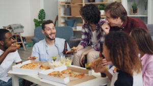 Meals for a Large Group: The Best Food Options in Carol Stream 2 Group of friends sharing pizza and drinks at a casual gathering, enjoying a crowd-friendly meal together.