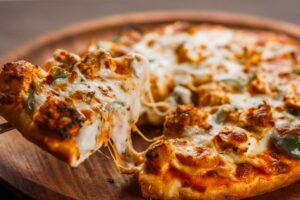 Chicago Deep Dish Pizza in Indianapolis: Bringing Big Flavor to Every Bite 1 Deep-dish pizza slice being lifted, cheese stretching.