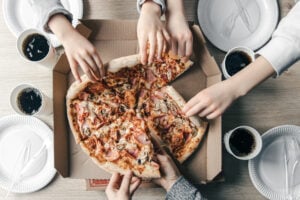 Pizza Places in Naperville IL: Finding Great Pizza for Every Occasion 2 Family sharing pizza and sides at the dinner table.