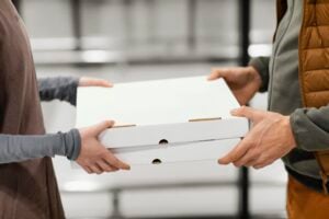 Order To-Go Food Near Me: Easy Meals for Busy Days and Last-Minute Cravings 1 Friends enjoying pizza together at home while one person uses a smartphone.